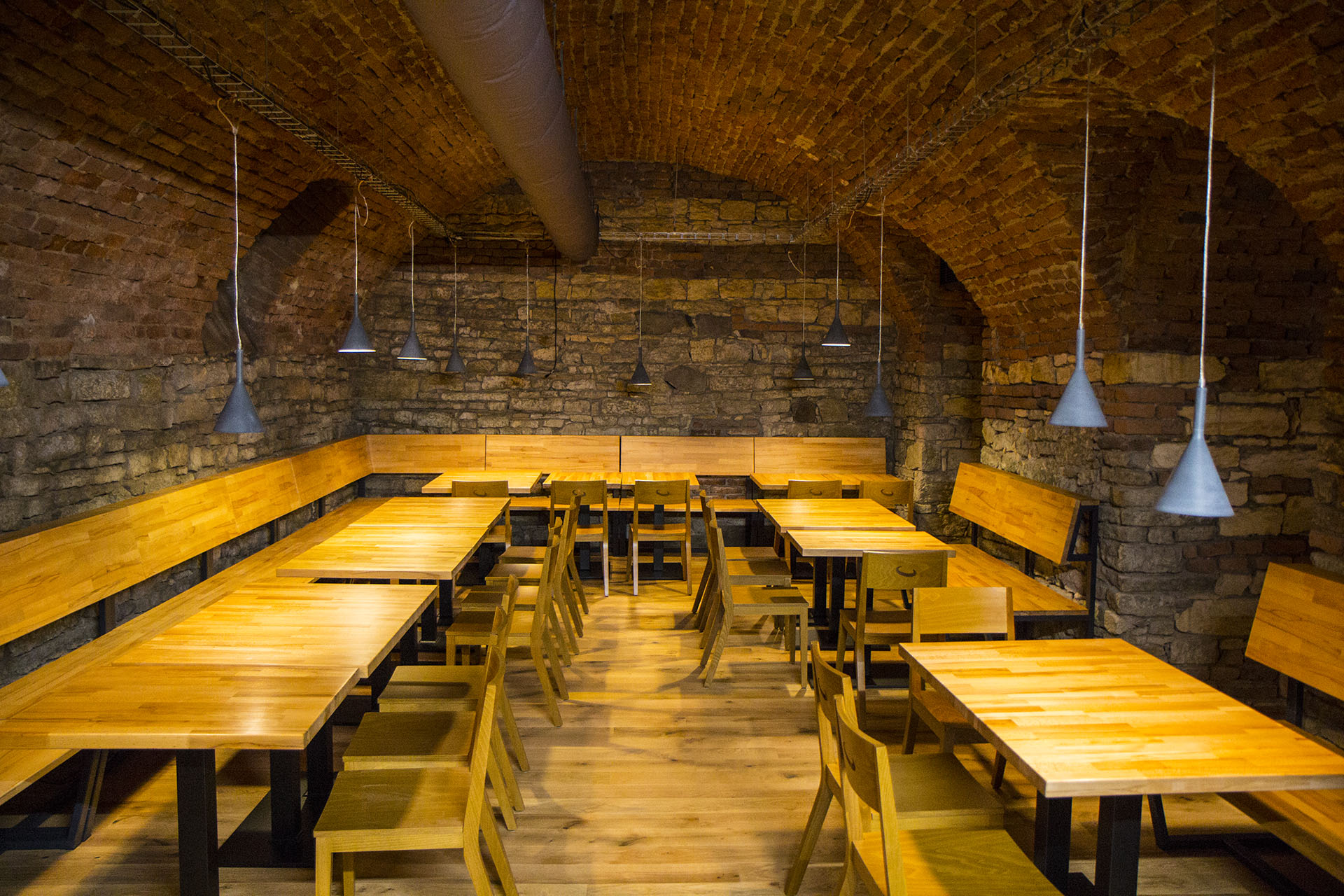 Salle principale d'Andělský Pivovar avec vue sur la salle de brassage