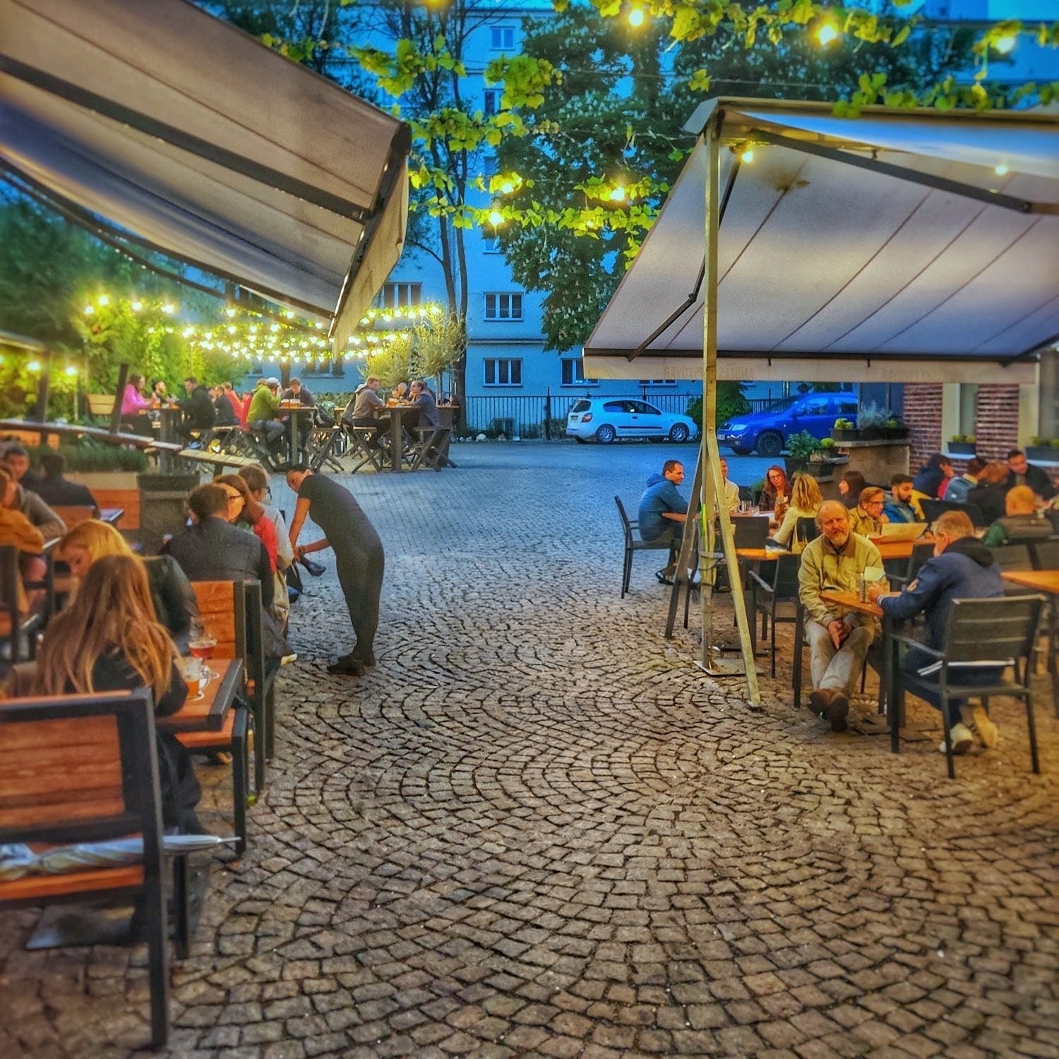 Jardin à bière estival avec places assises sous les arbres